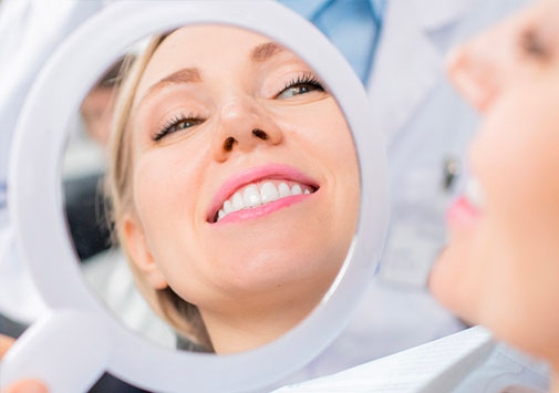 Woman admiring smile in mirror